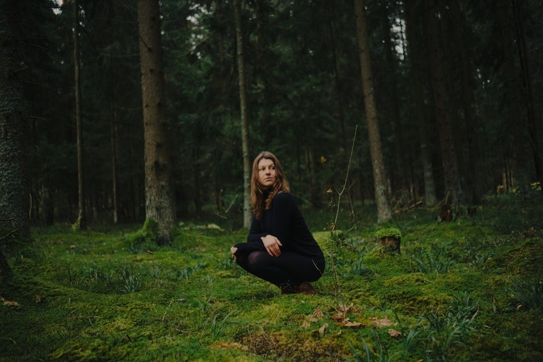 Femme assise seule dans une forêt dense et verdoyante