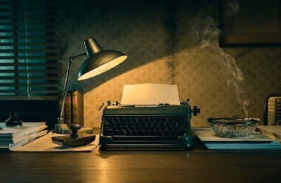 Machine à écrire éclairée, entourée de livres et de fumée