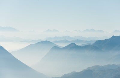 Paysage de montagnes bleutées émergeant d’une brume légère