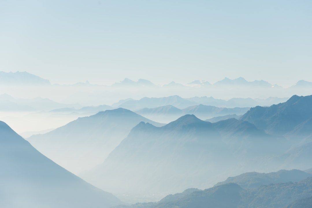 Paysage de montagnes bleutées émergeant d’une brume légère