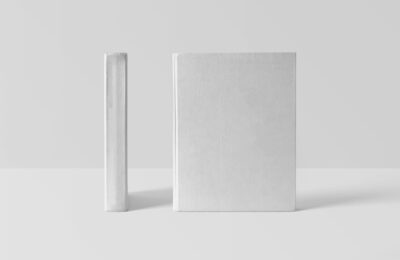 Deux livres blancs sans titre, présentés debout sur fond gris